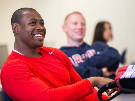 A smiling person sitting in a classroom.